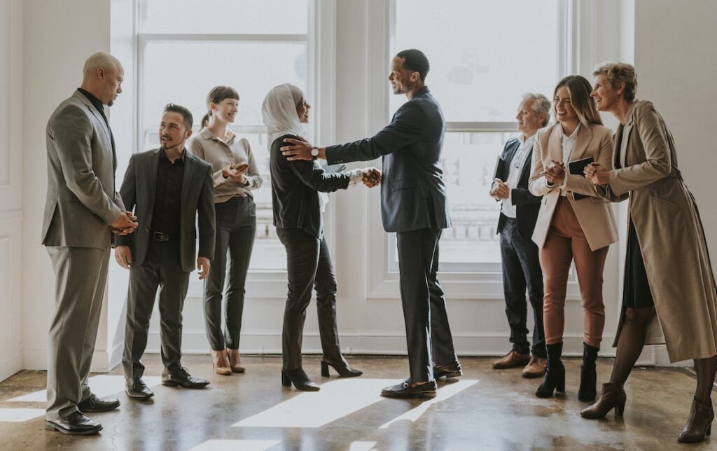 A Diverse Group of Businesspeople congratulate a colleague on getting a promotion.