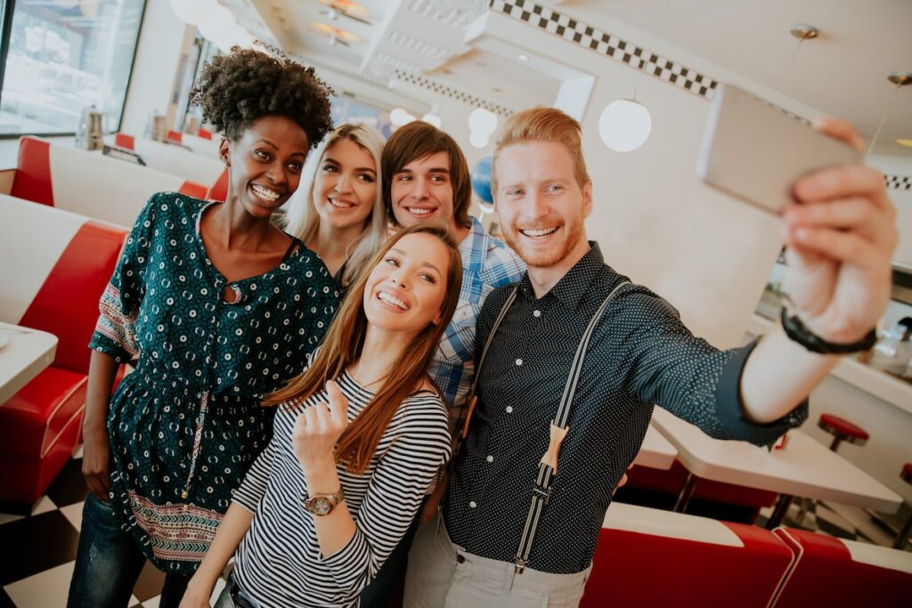 A group of workers take a selfie with a co-worker after receiving a promotion.
