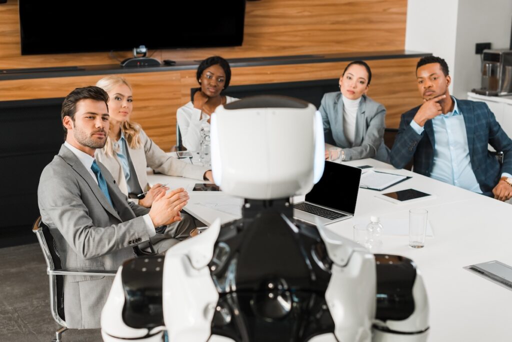 A group of businesspeople looking to a robot for ai recruiting help.