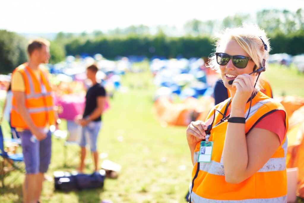 A festival worker uses a radio while enjoying her summer job.